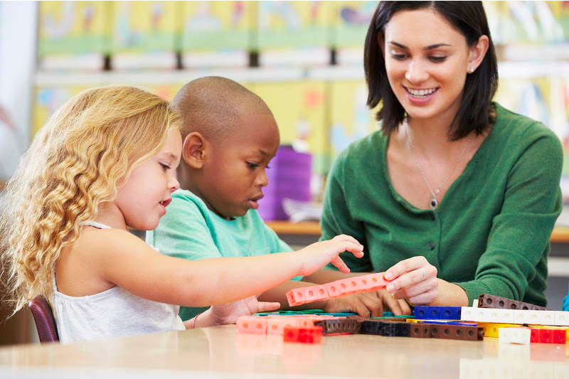image of a child counting snap cubes with a teacher