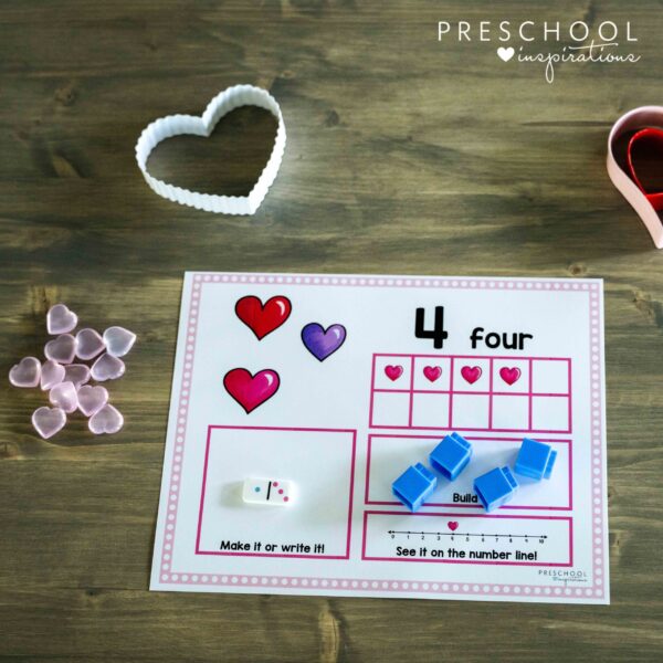 close up of a valentine's day counting mat showing four hearts in a 10-frame for the number four