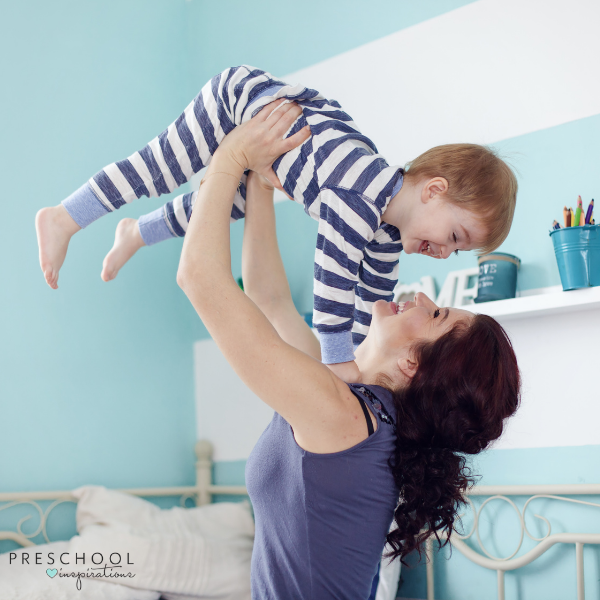 a mother throws her smiling little boy in the air